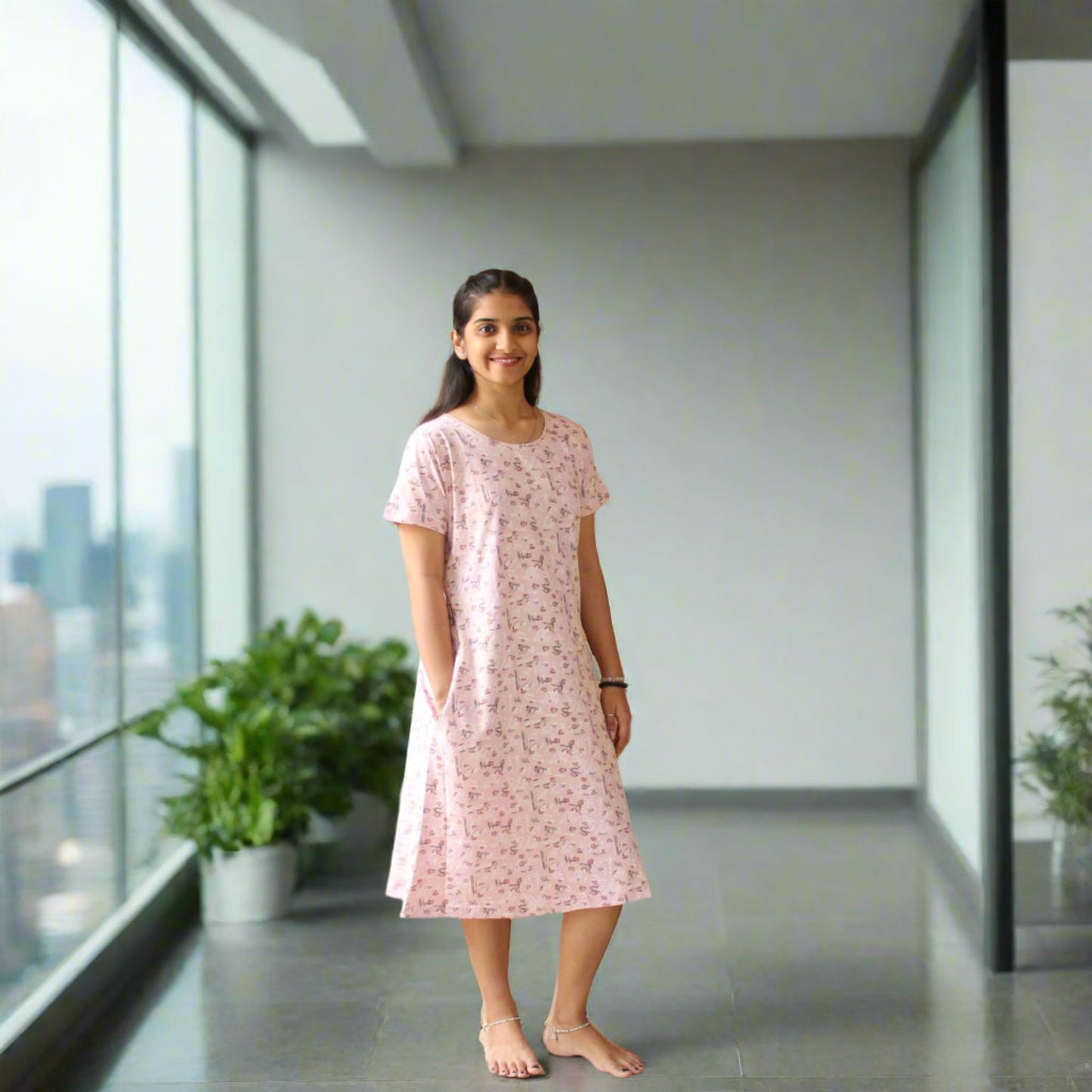 women wearing light pink cotton short night dress, standing in a balcony posing hands in pocket