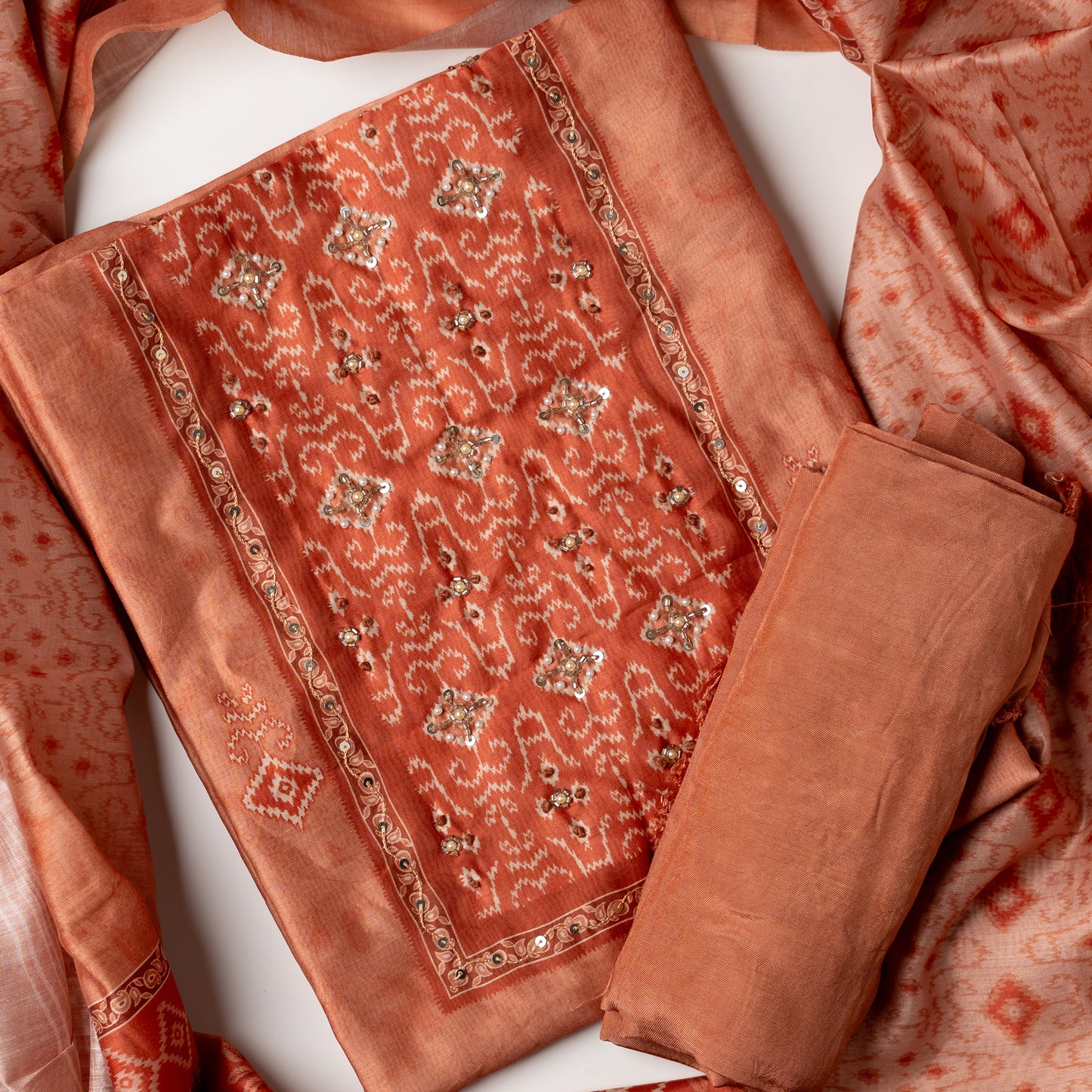 dark orange color unstitched dress material with patola prints and stone work