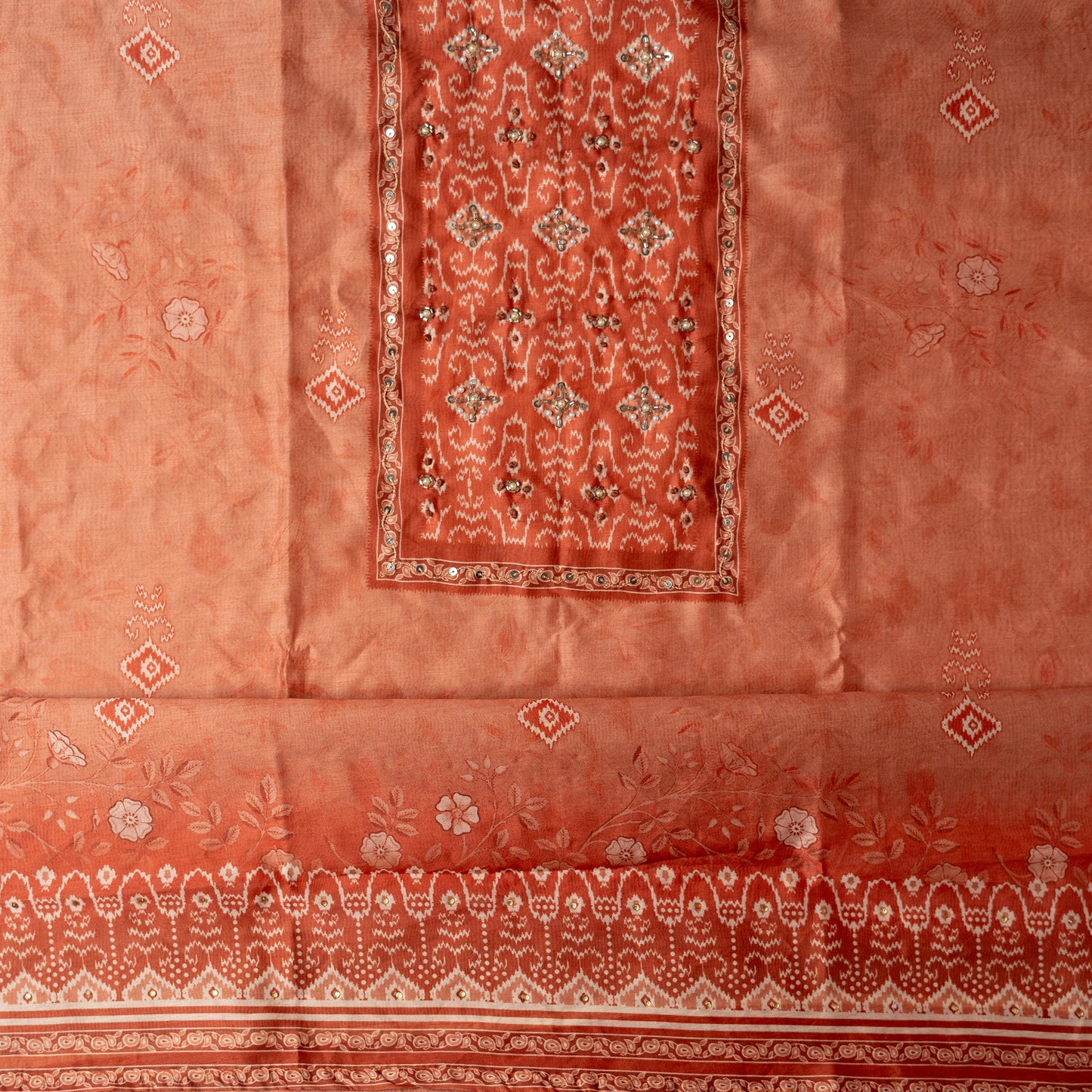 bring orange color silk top with floral prints and patola prints along with stone work on the yoke