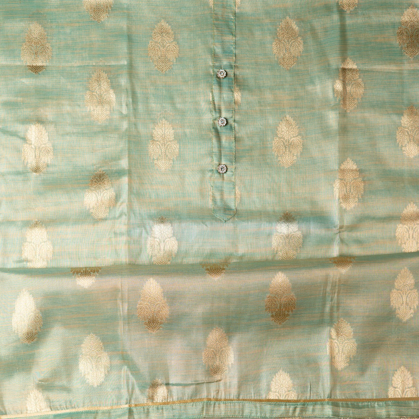 An elegantly crafted Tissue Silk Party wear dress material. A set best suited to gift bride to be or your loved on your anniversary. Tissue silk top with golden color embossed designs, it has show buttons in neck area, also golden color borders in side.