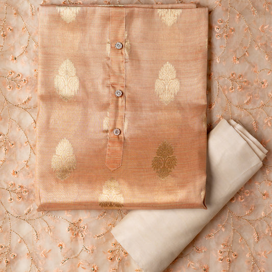 An elegantly crafted Tissue Silk Party wear dress material. A set best suited to gift bride to be or your loved on your anniversary. Tissue silk top with golden color embossed designs, it has show buttons in neck area, also golden color borders in side. Tissue silk dupatta with embroidery work with the same color thread of top and also golden color threads. Cream color cotton silk bottom.