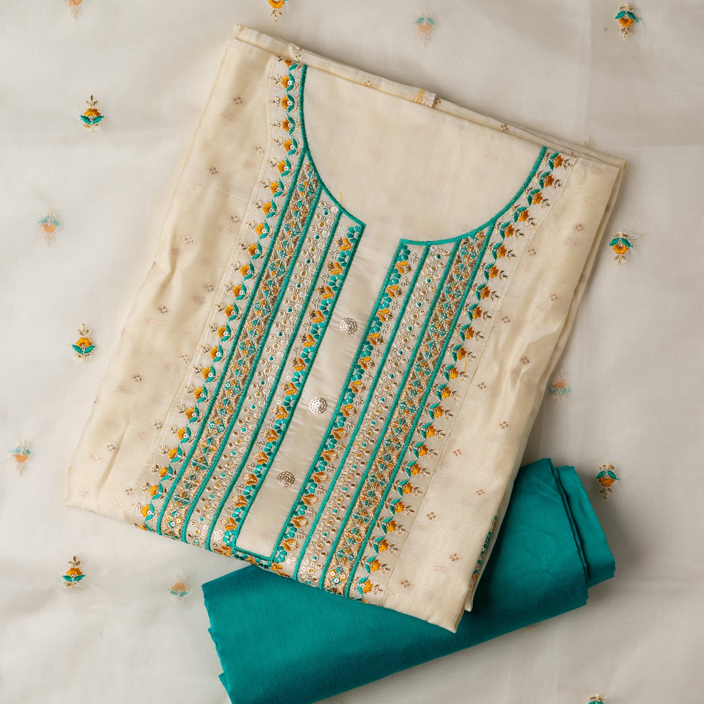 A unique design , perfect for your loved ones . Gift this beautifully embroidered chanderi silk unstitched salwar suit material. Top with embroidery work on neck line and golden thread jacquard small design weaving all over. The border of the dress is also embroidered elegantly. Matching cream color dupatta with embroidery work all over and on the borders. Green color cotton silk bottom.