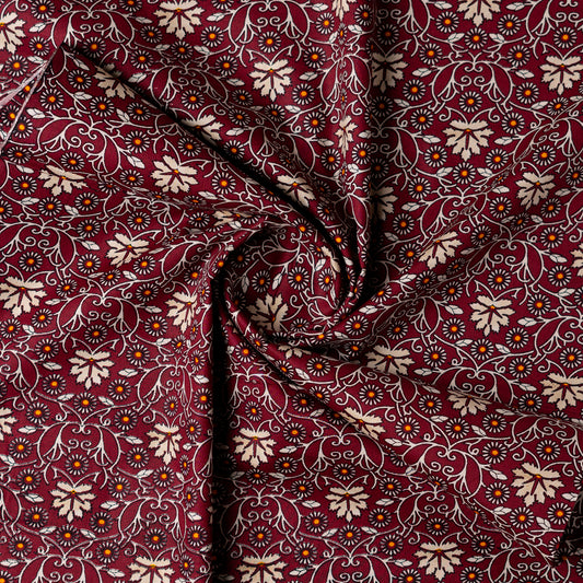 cotton printed fabric in wine red color, it has cream and orange color floral design, small orange dotted design