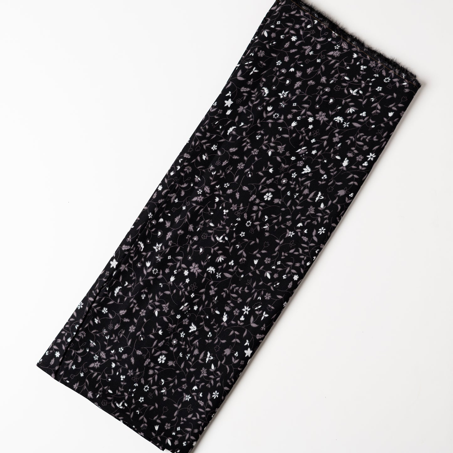 Black color rayon fabric with white and grey color floral prints, this is a small print elegant design.