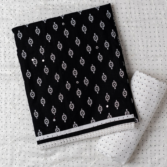 Cotton black color dress material with beautiful print design in white color on top, mirror work. It has white color lace on the borders. Chiffon dupatta with embroidery work in white color and black dotted prints. Cotton white color bottom with black dots.