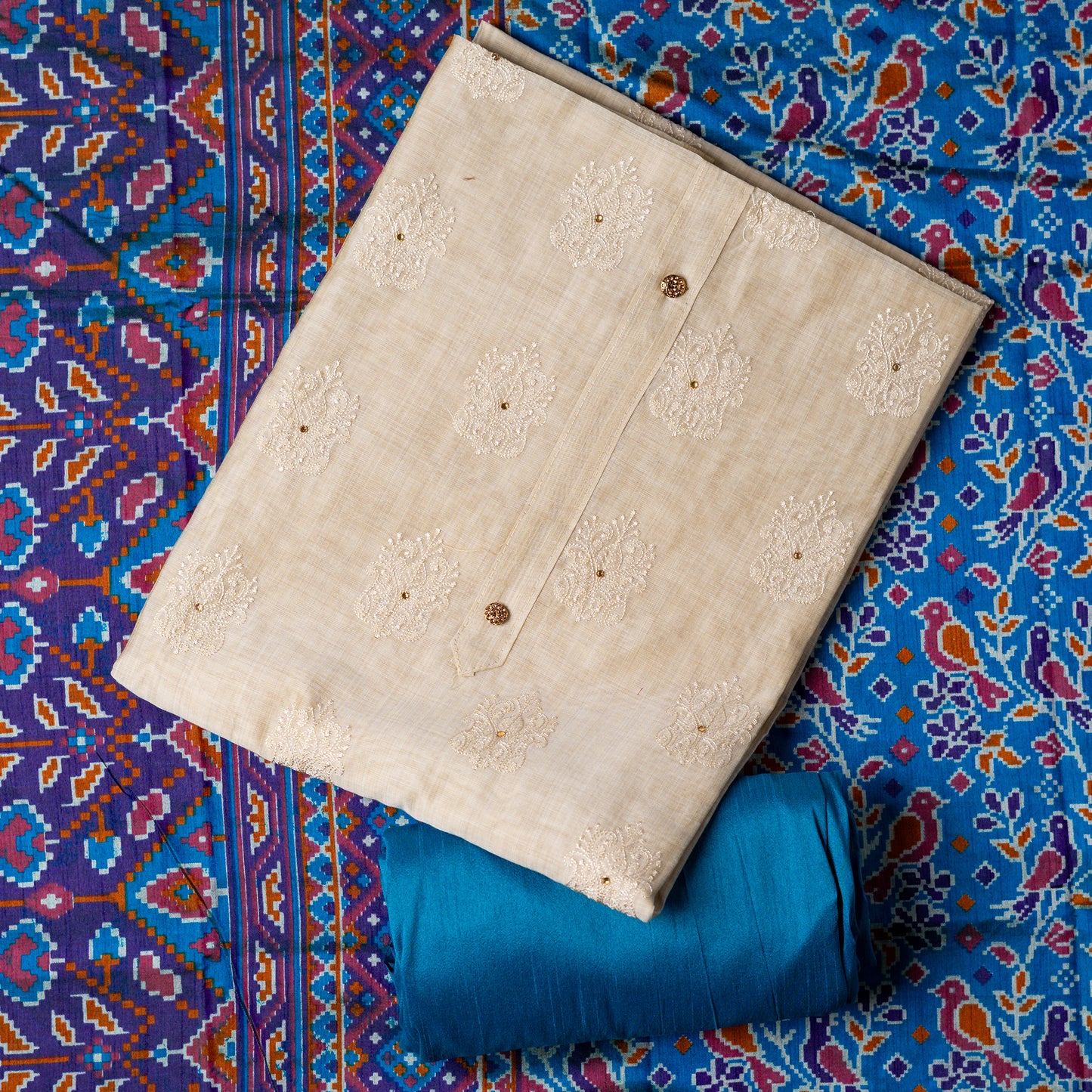 Chanderi silk dress material with embroidery and sequins work, the embroidery work is done with the same color thread of the top which gives a very elegant look. The top has show buttons and golden color piping in the border colorful digital printed silk dupatta , teal blue color cotton silk bottom.