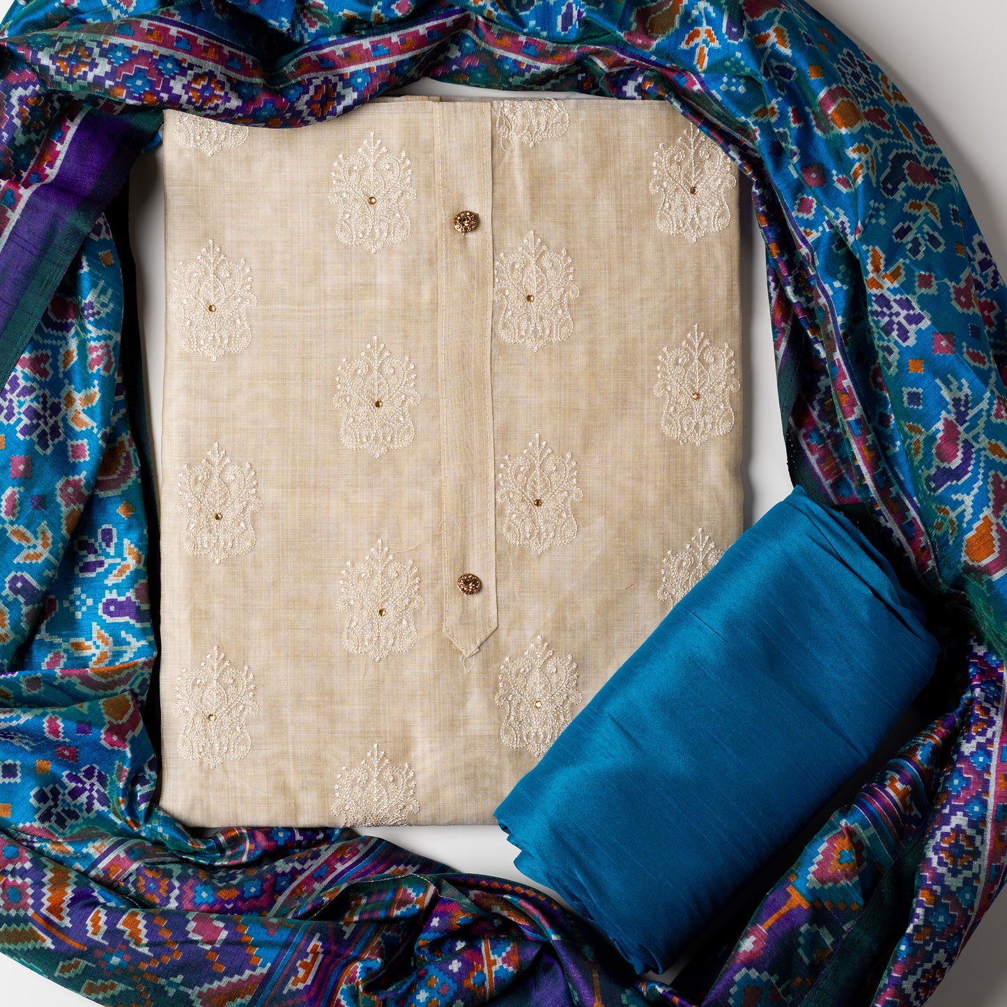 Chanderi silk dress material with embroidery and sequins work, the embroidery work is done with the same color thread of the top which gives a very elegant look. The top has show buttons and golden color piping in the border colorful digital printed silk dupatta , teal blue color cotton silk bottom.