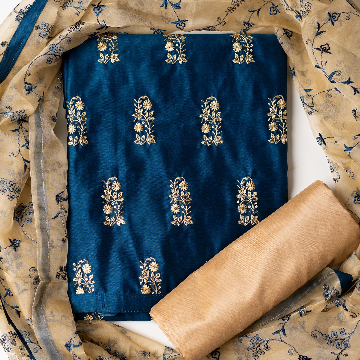 This beautiful chanderi silk dress material set will suit you for any of your functions, be it evening party, bridal wear, birthday party or anniversary gift. Blue color top with elegant embroidery and sequins work. Cream color silk dupatta with matching blue color embroidery work is giving the set a perfect party wear look. Cotton silk cream color border.
