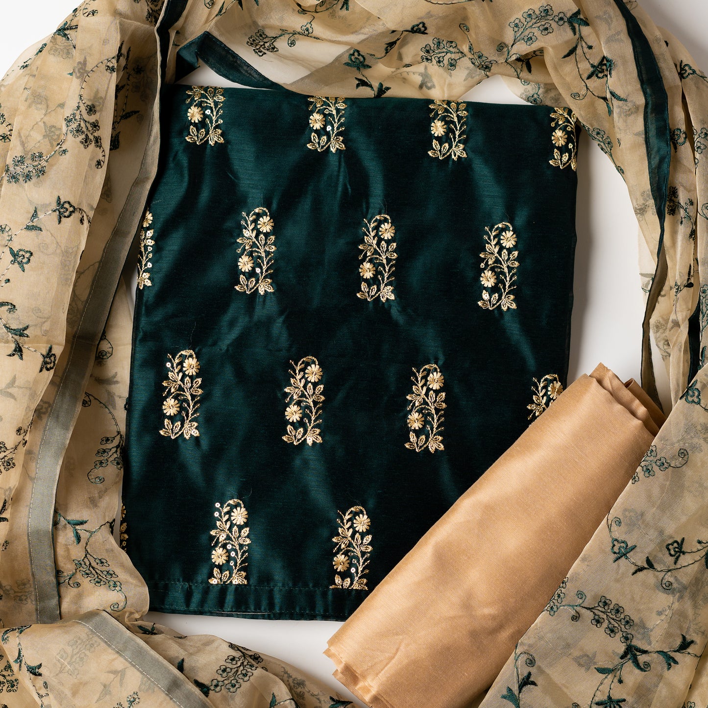 This beautiful chanderi silk dress material set will suit you for any of your functions, be it evening party, bridal wear, birthday party or anniversary gift. Green color top with elegant embroidery and sequins work. Cream color silk dupatta with matching green color embroidery work is giving the set a perfect party wear look. Cotton silk cream color border