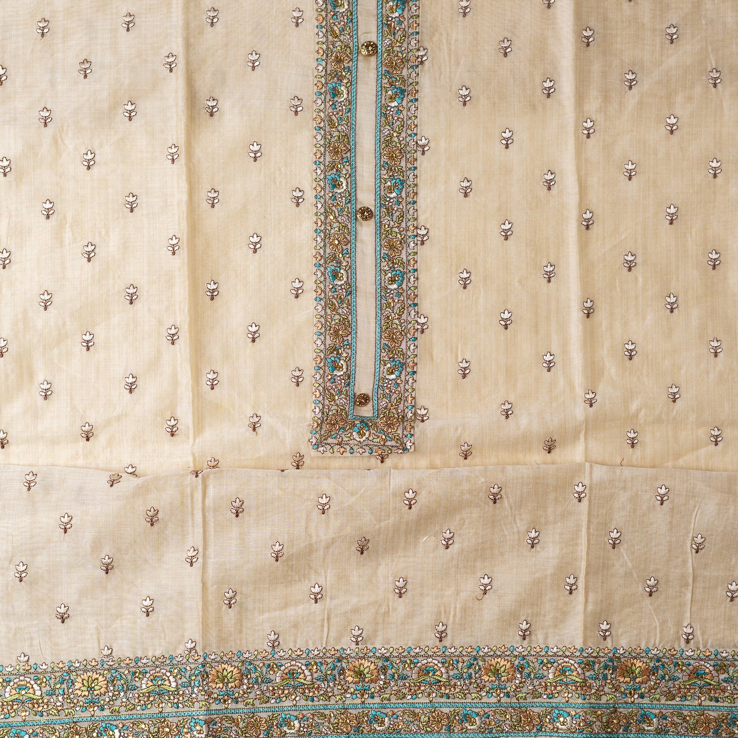 Ivory color Chanderi Silk top with floral embroidery all over the body in the front and elegant sea green color embroidery work in neck line with show buttons, it has embroidery work in the border also