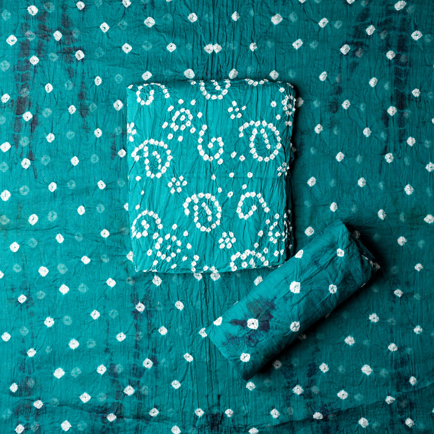 Teal Blue color top with white bandhej designs, Teal blue color bottom with shibori designs in navy. Teal blue color dupatta with shibori designs in navy and golden borders.