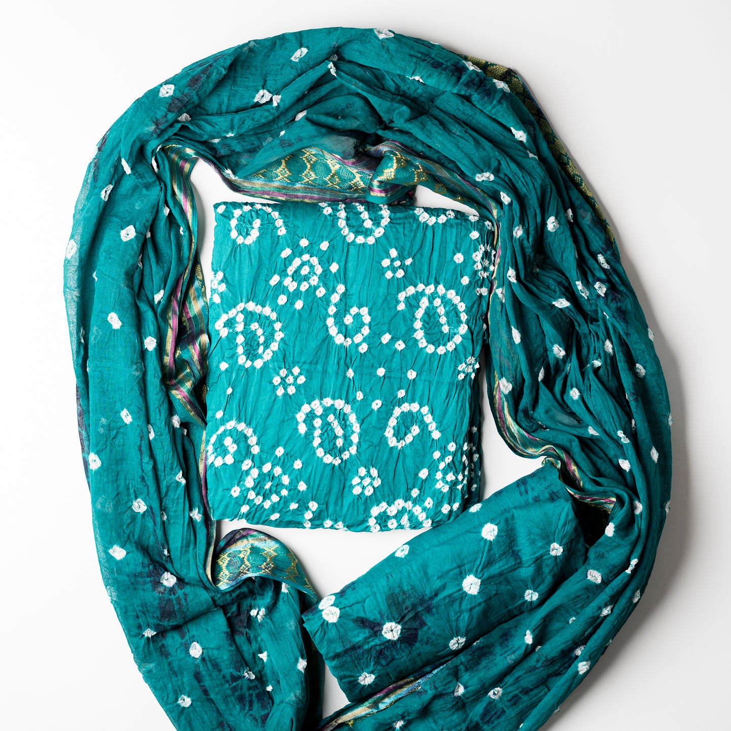 Cotton bandhani dress material set, Teal Blue color top with white bandhej designs, Teal blue color bottom with shibori designs in navy. Teal blue color dupatta with shibori designs in navy and golden borders.