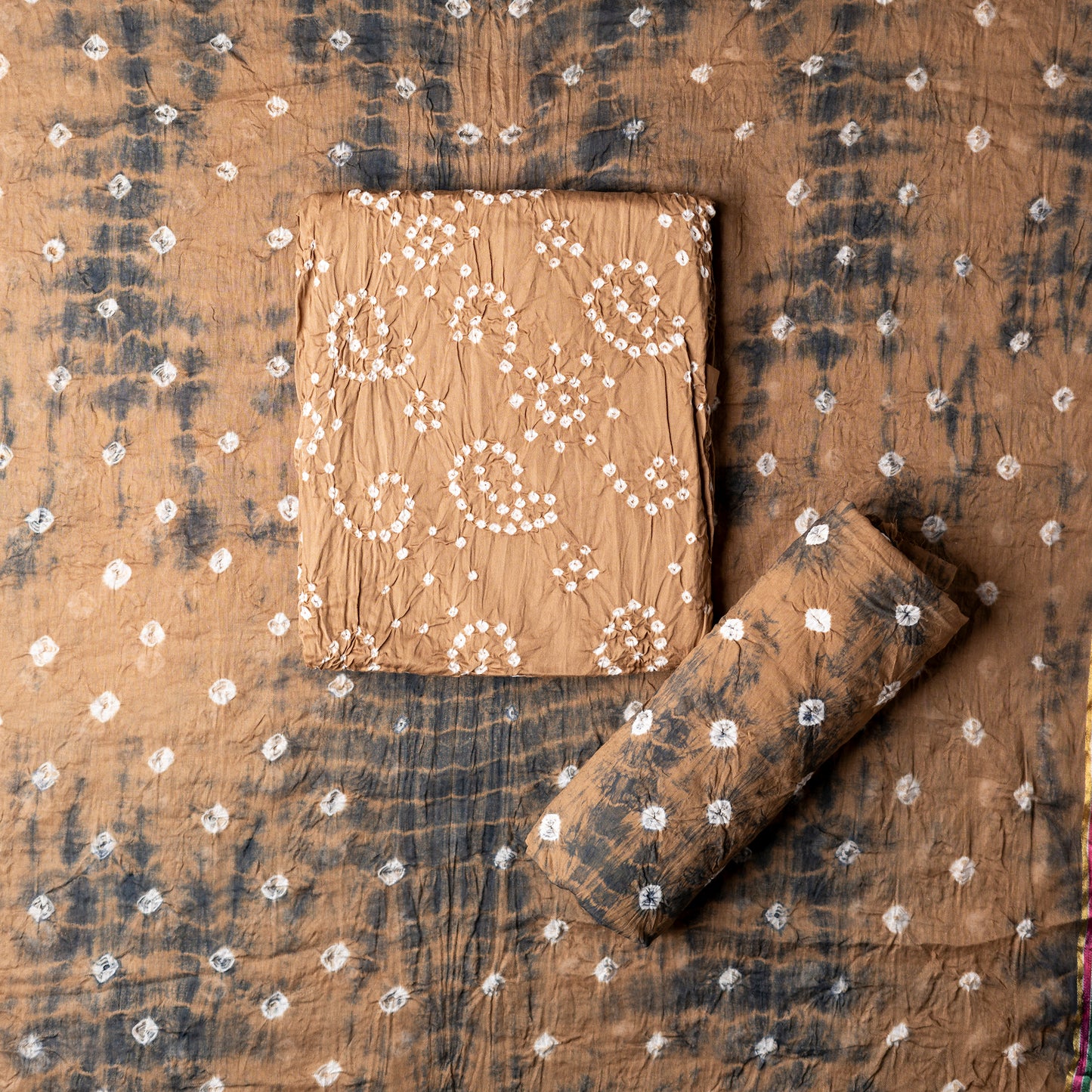 Cotton bandhani dress material, Brown color top with white bandhej designs,  Brown color bottom with shibori designs in black color.  Brown color dupatta with shibori designs in black color and golden borders.