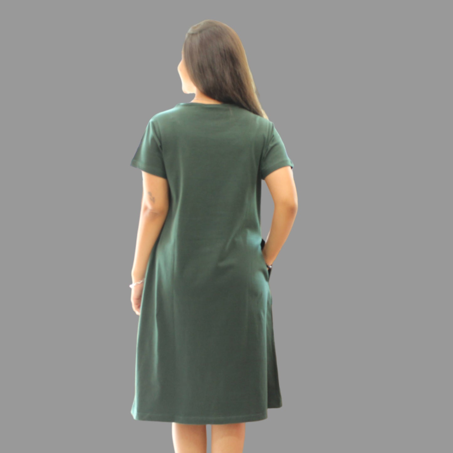 women wearing bottle green t shirt and standing backwards, back view pose
