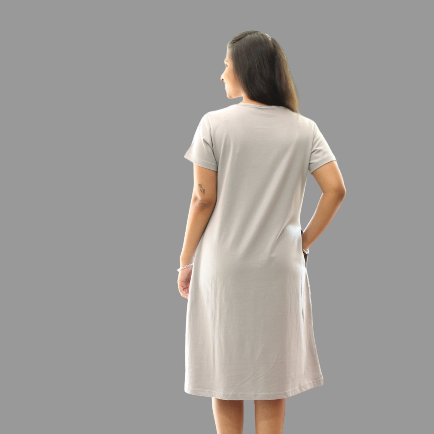 women wearing light grey knee length t shirt, standing backwards