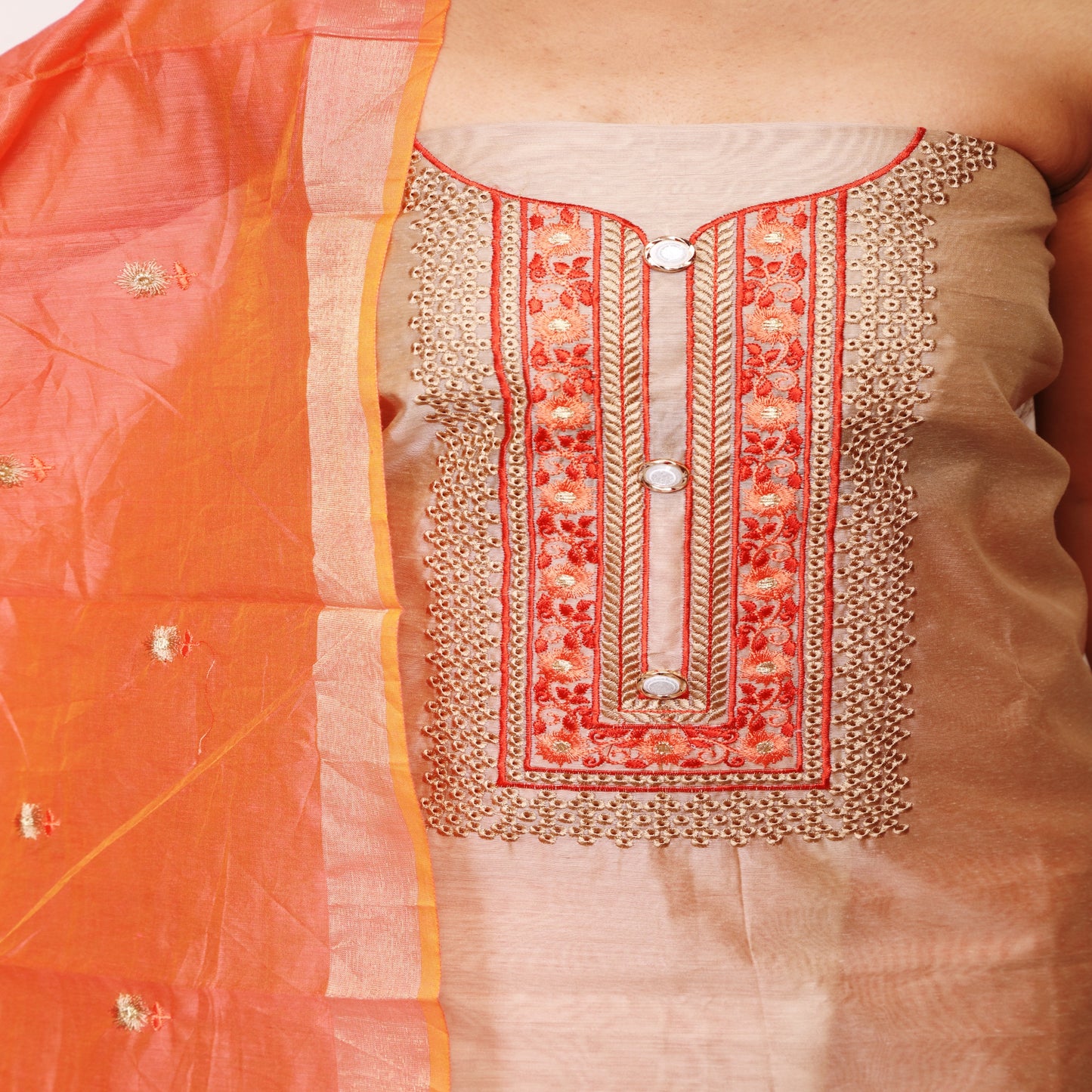 close-up view of light cream color top with embroidery on yoke, chanderi dupatta with embroidery, cotton plain peach bottom