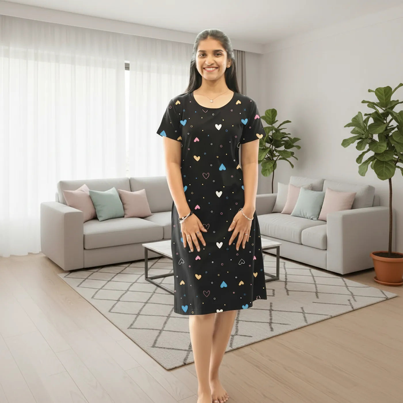Women wearing black color hosiery cotton knee length short nighty with hearts in multiple color print, this is an all over printed short nighty