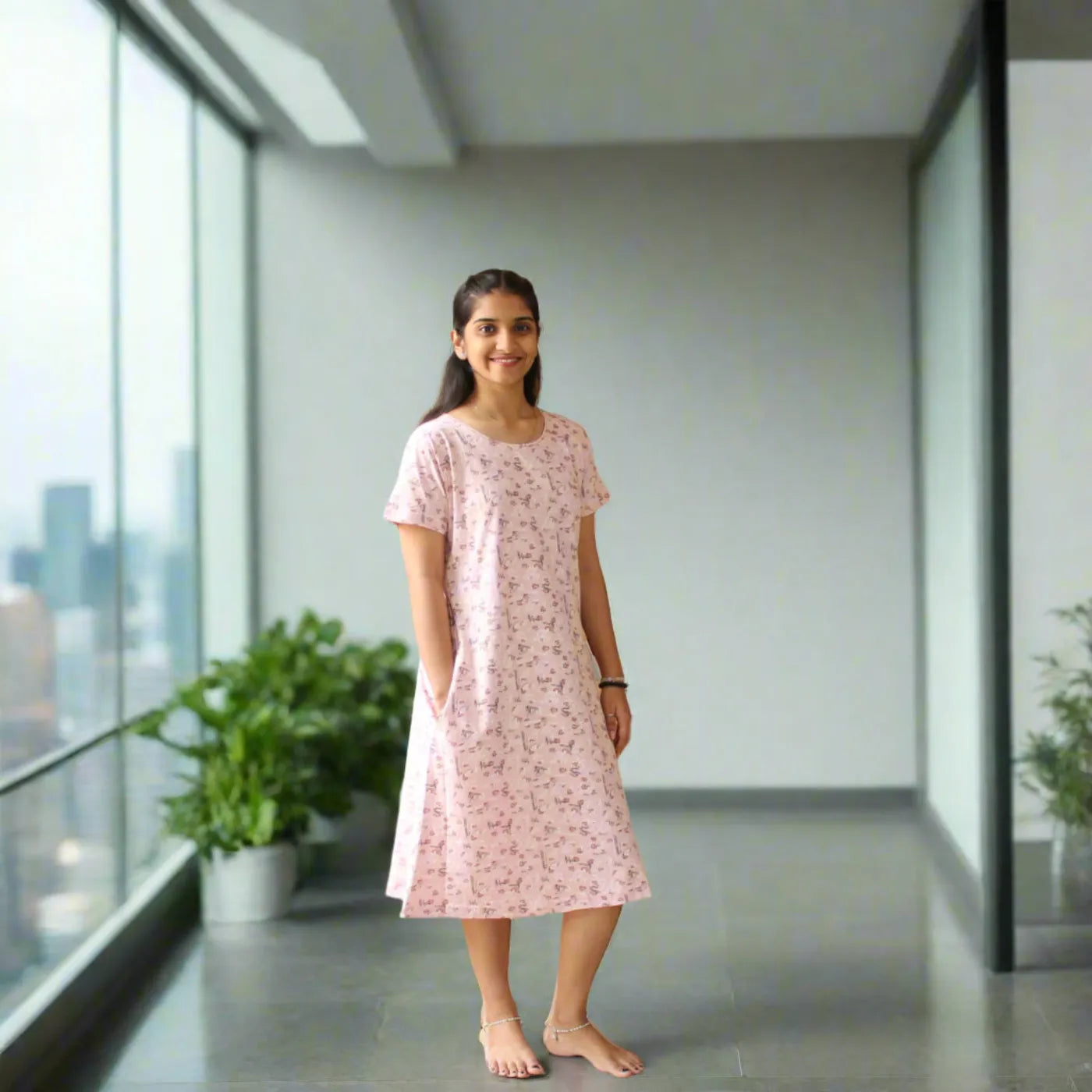 women wearing light pink cotton short night dress, standing in a balcony posing hands in pocket