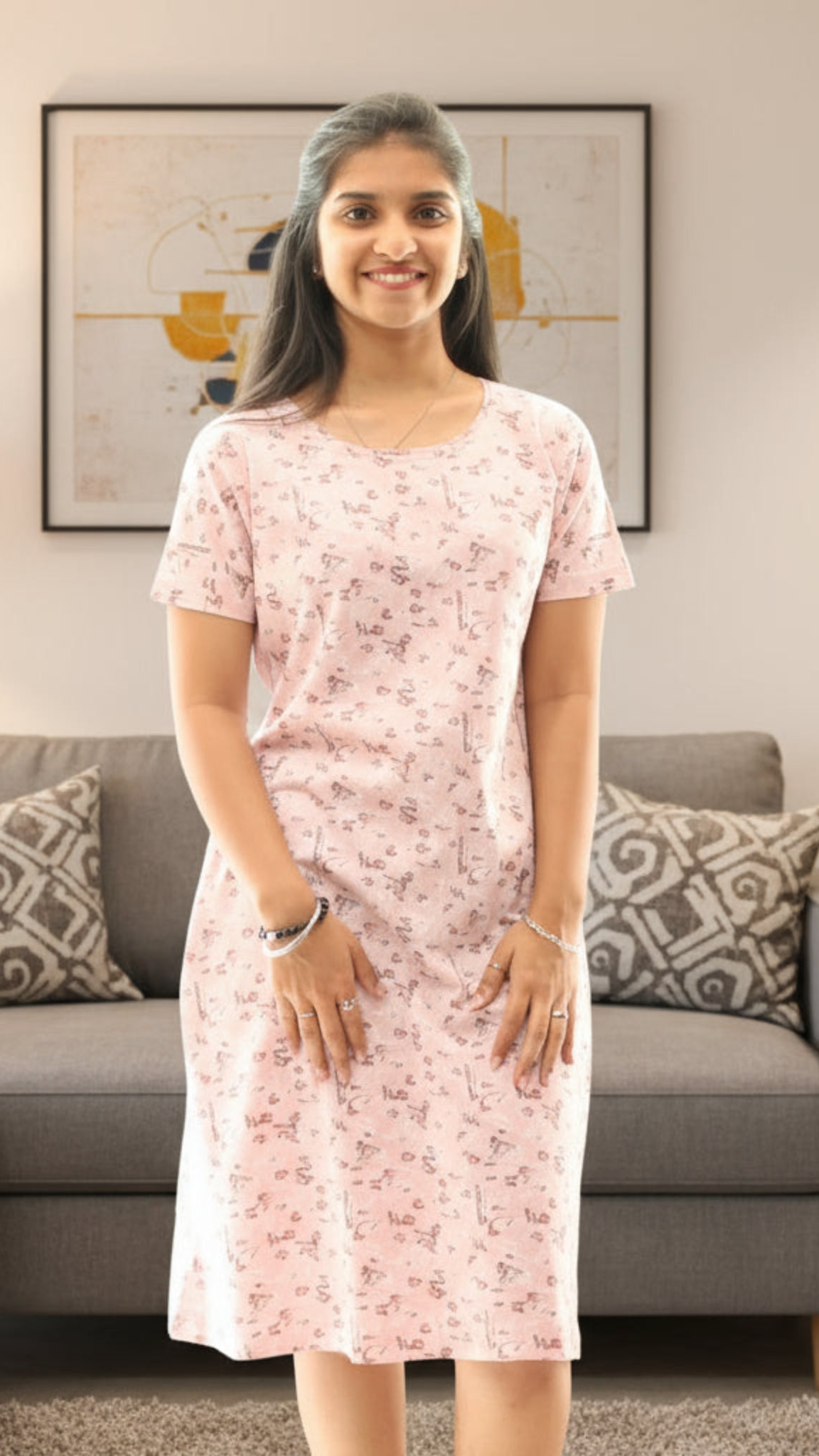 Woman wearing a pink floral dress standing in a living room.