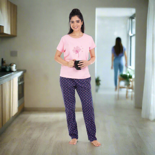Women wearing pink t shirt with design, navy blue pyjama with pritns, holding a coffee mug in hand