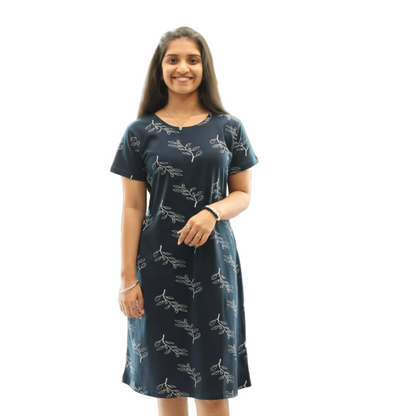 Woman wearing a navy blue dress with white floral patterns on a white background
