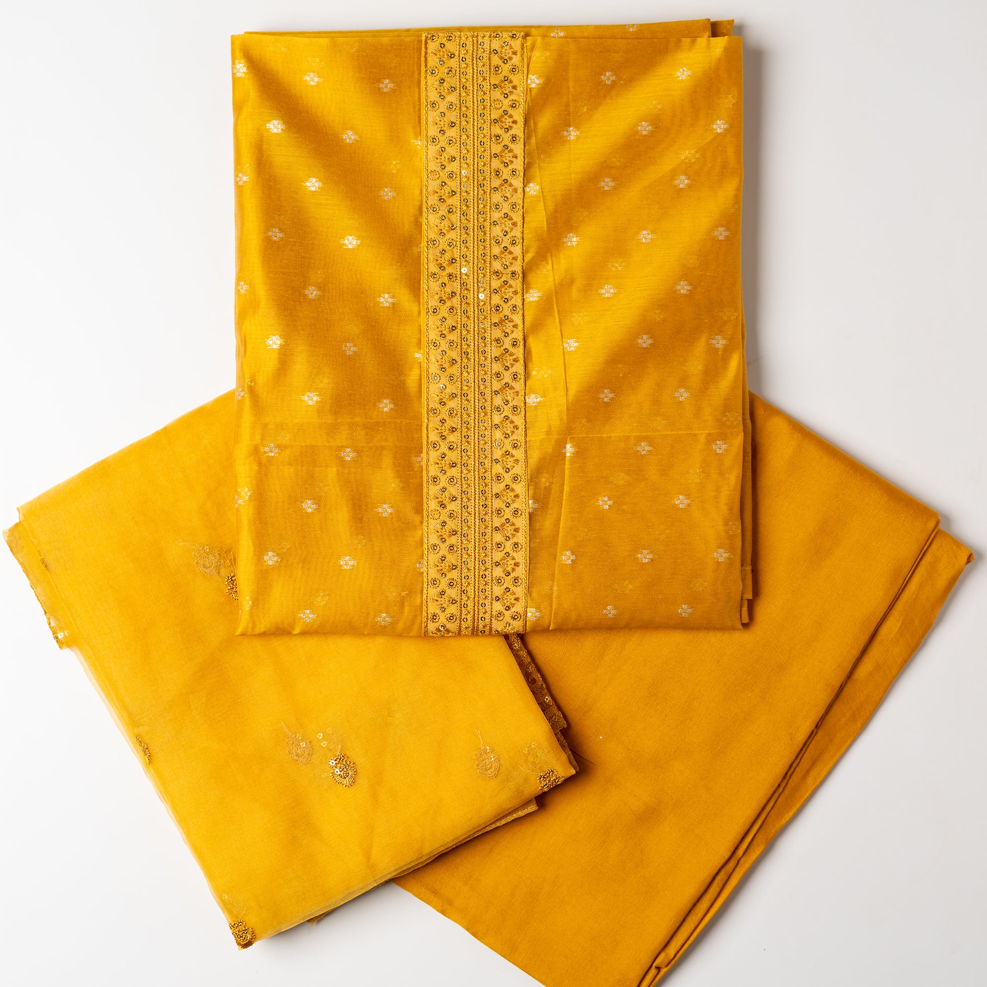 golden yellow color Beautiful chanderi silk dress material with embroidery and sequins work on neck line. It has jacquard weaving in golden threads all over the top. Tissue silk dupatta with elegant embroidery and sequins work all over dupatta and at the borders. Golden Yellow color cotton silk bottom  matching the top and dupatta.