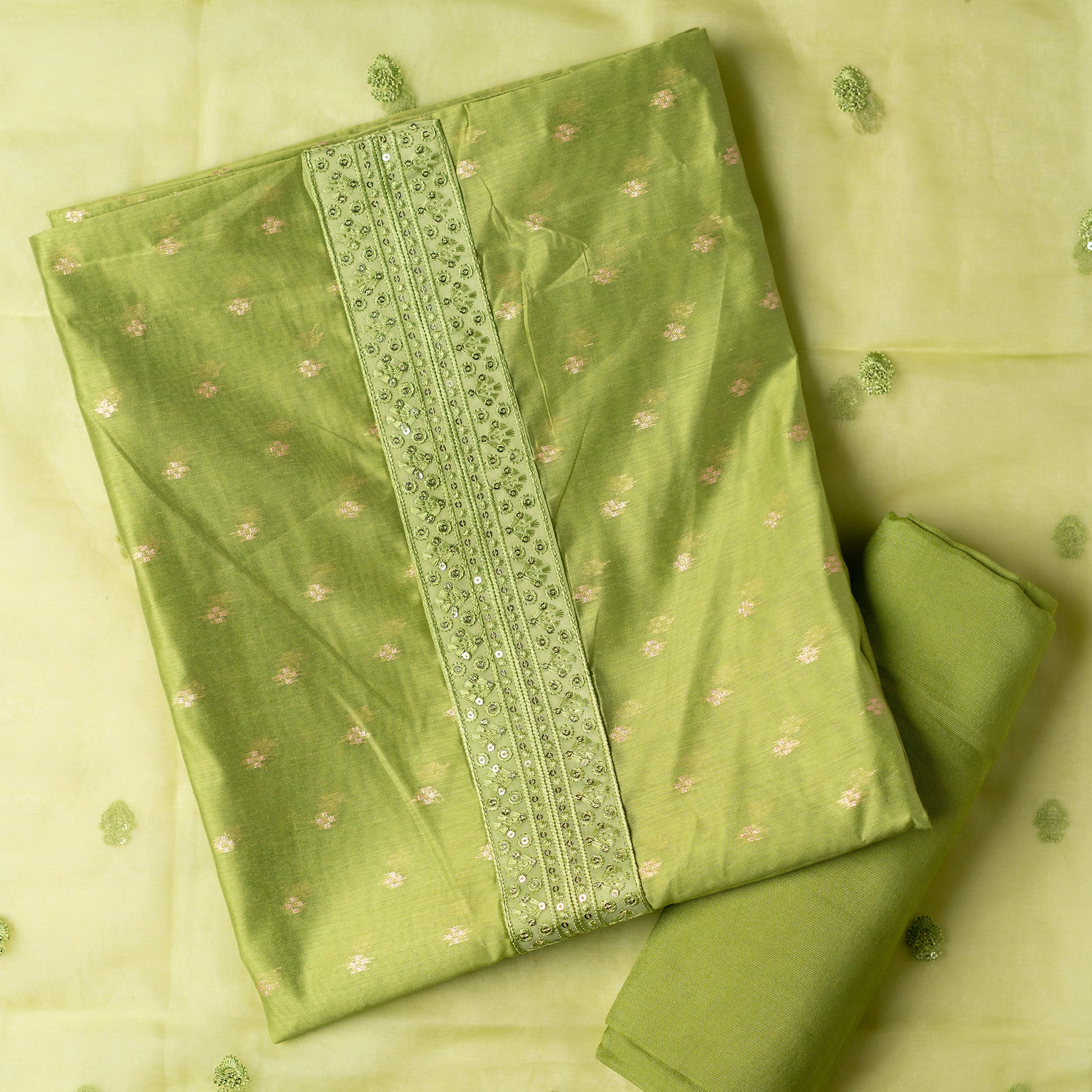parrot green color Beautiful chanderi silk dress material with embroidery and sequins work on neck line. It has jacquard weaving in golden threads all over the top. Tissue silk dupatta with elegant embroidery and sequins work all over dupatta and at the borders. Parrot green color cotton silk bottom  matching the top and dupatta.