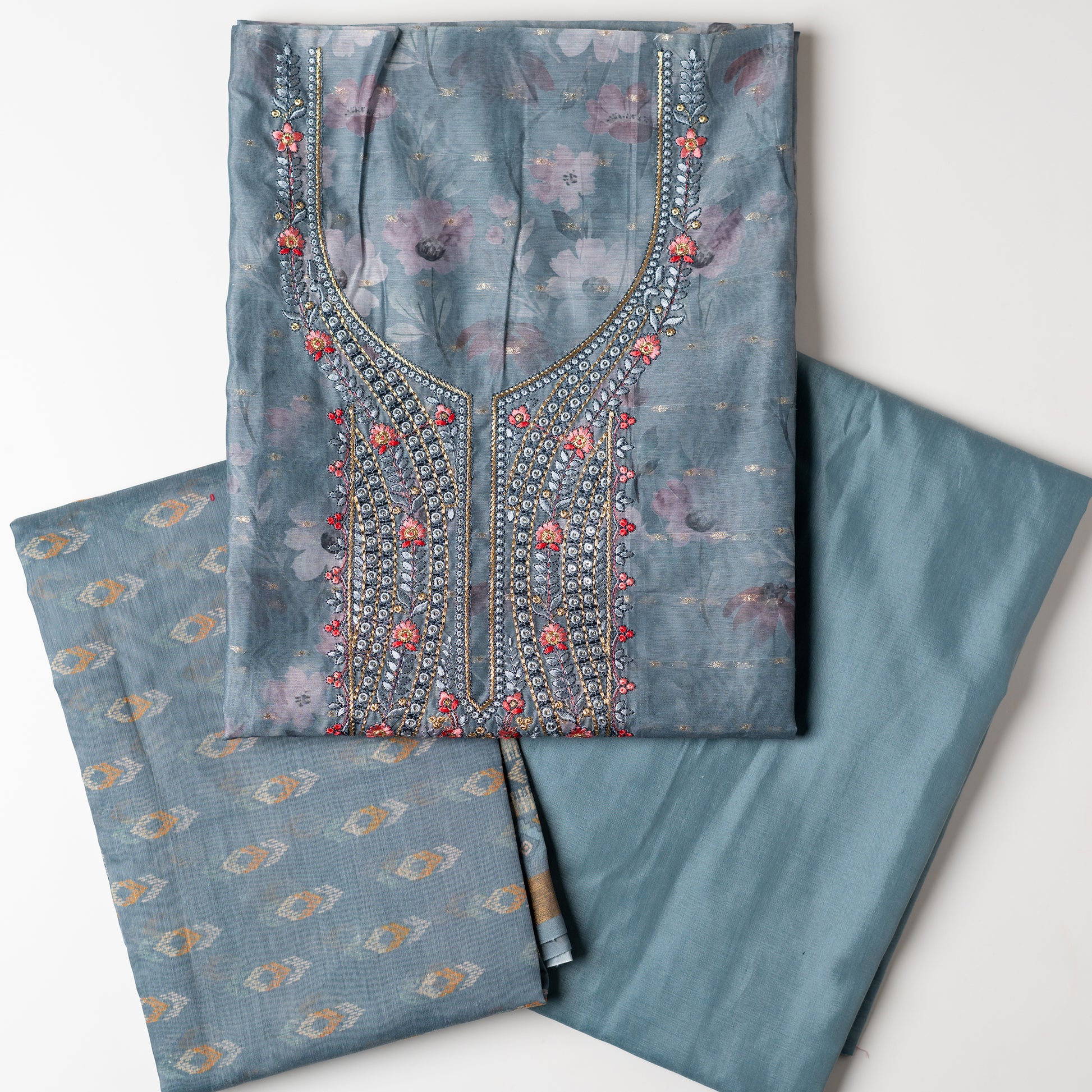 It's just awesome, pick any color of this design and we are sure you will love it the most. Beautiful embroidery work  in the neck. Sober floral prints and jacquard weaving in golden thread is giving the set a royal look. Silk dupatta with exact same design as the top with golden color border. Pastel grey color bottom matching exactly as the top and dupatta.