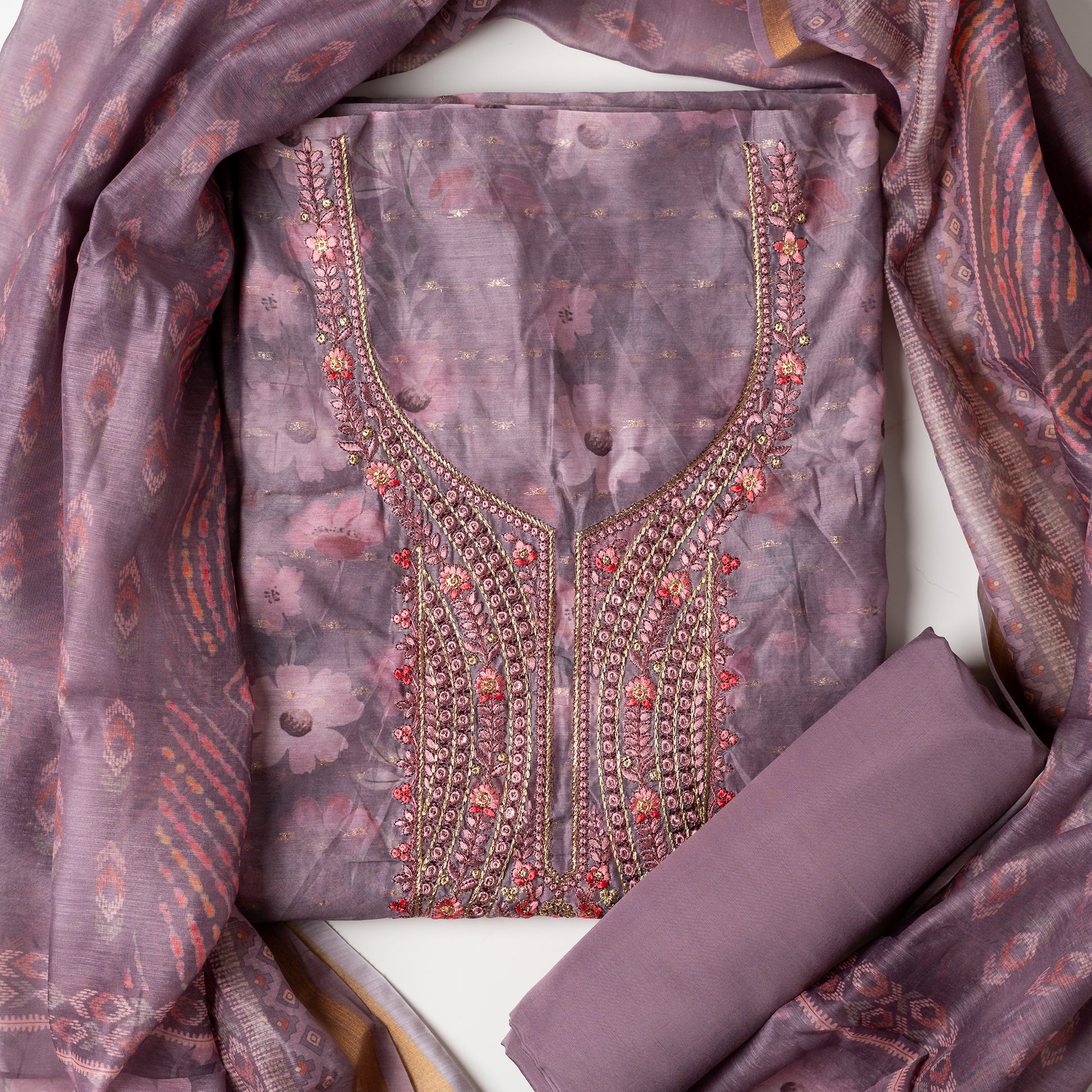 It's just awesome, pick any color of this design and we are sure you will love it the most. Beautiful embroidery work  in the neck. Sober floral prints and jacquard weaving in golden thread is giving the set a royal look. Silk dupatta with exact same design as the top with golden color border. Pastel purple color bottom matching exactly as the top and dupatta.