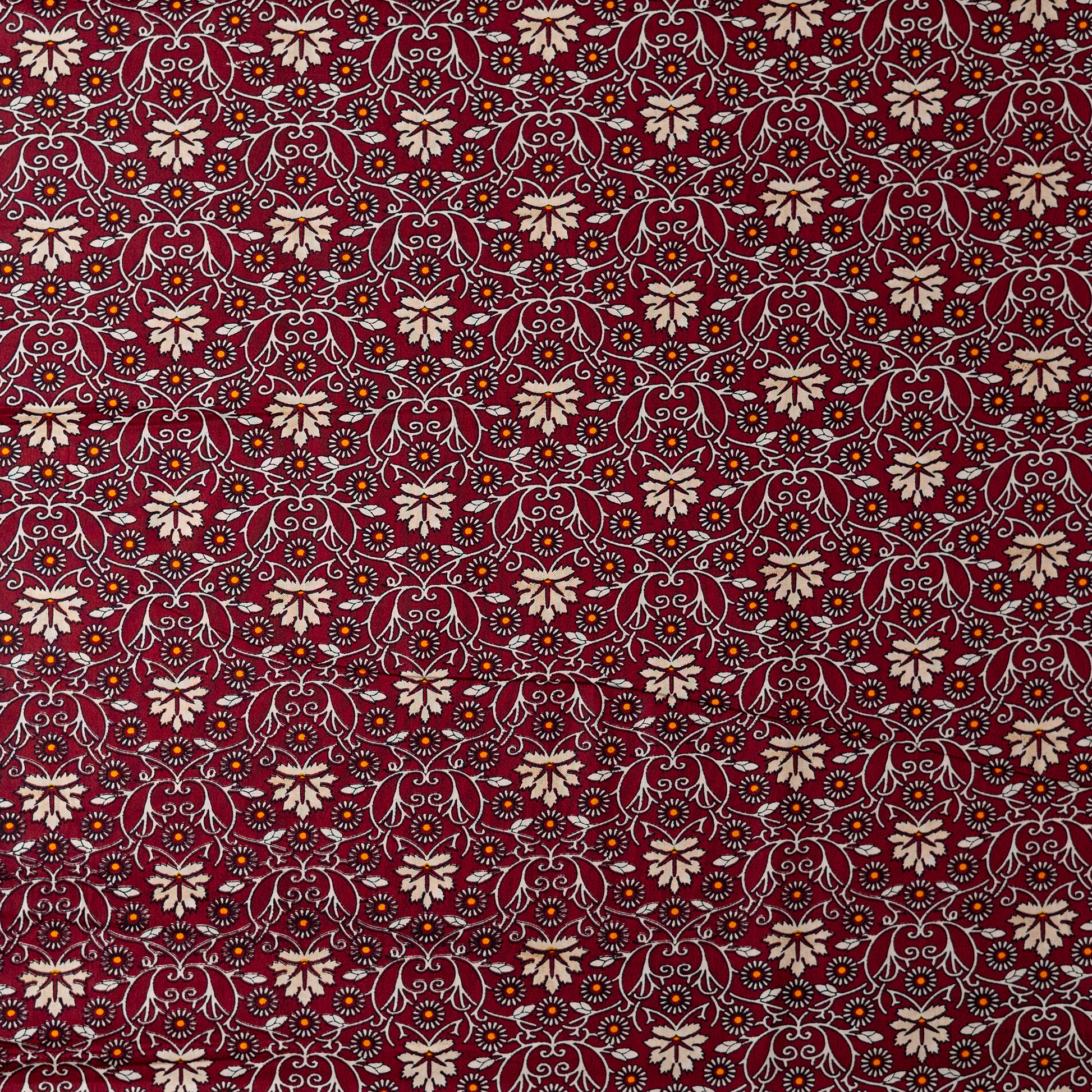 cotton printed fabric in wine red color, it has cream and orange color floral design, small orange dotted design