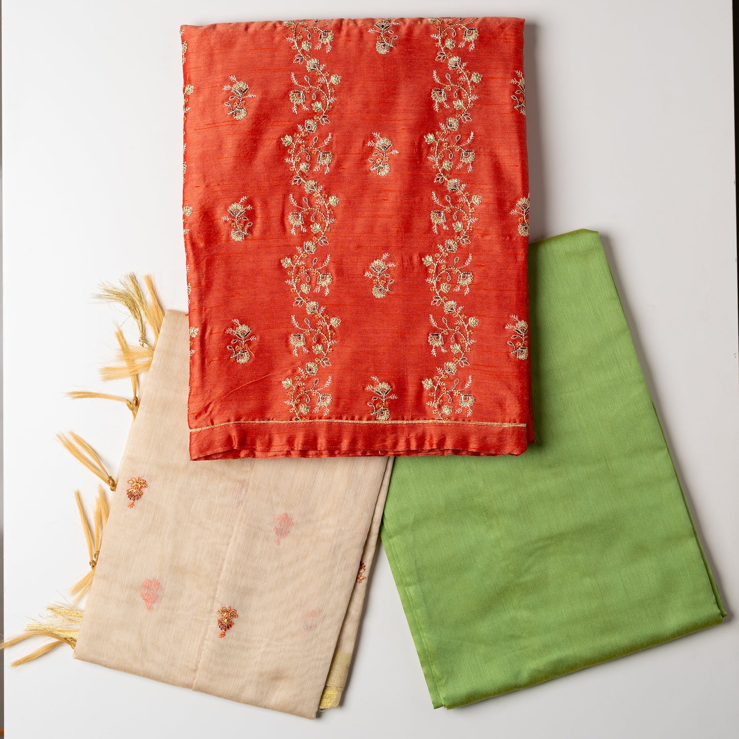 images of top , bottom and dupatta in folded style, Unstitched chanderi silk dress material set, peach color chanderi silk top with embroidery work, cream color chanderi silk dupatta with embroidery work, parrot green color cotton silk bottom