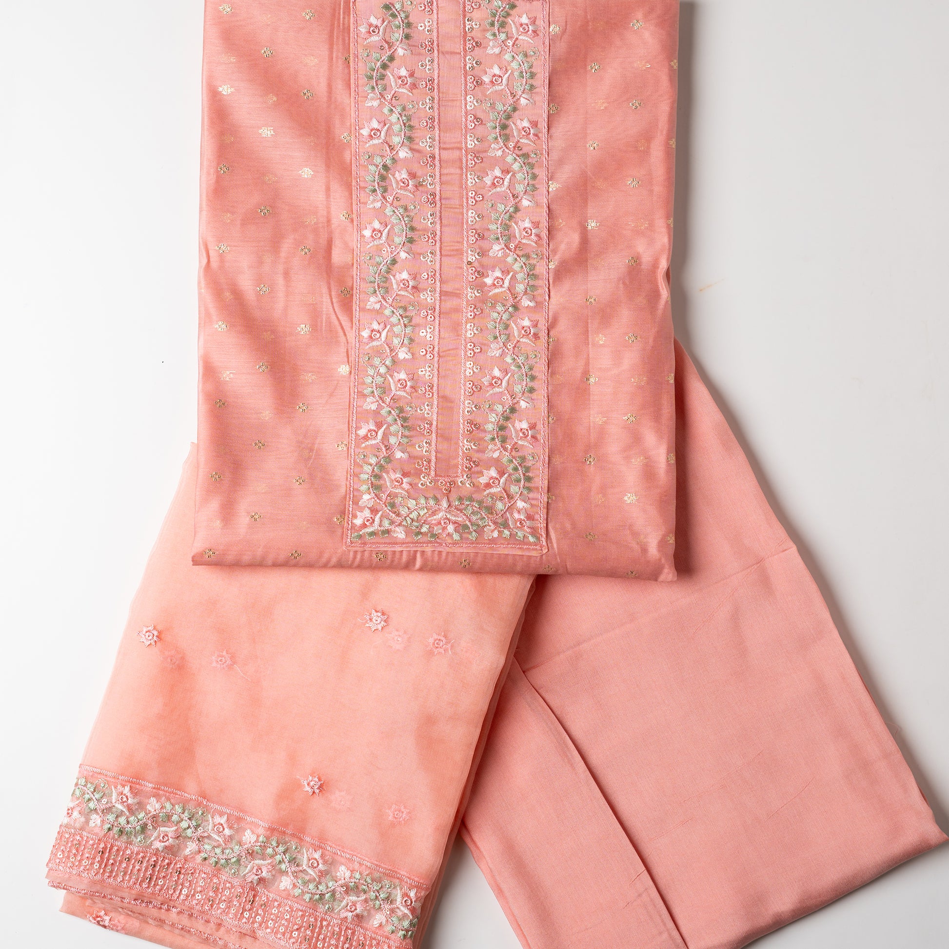 This is one of the best gift for your mom, a beautiful light peach color chanderi silk top with nicely crafted embroidery work in neck line, golden color jacquard weaving all over the body, embroidery work on the border of the dress matching the neck line, it has also golden color sequins work in the border. Beautiful silk dupatta with floral embroidery and the borders are perfectly in sync with the top border, embroidery work and sequins. Plain light peach color soft cotton silk bottom