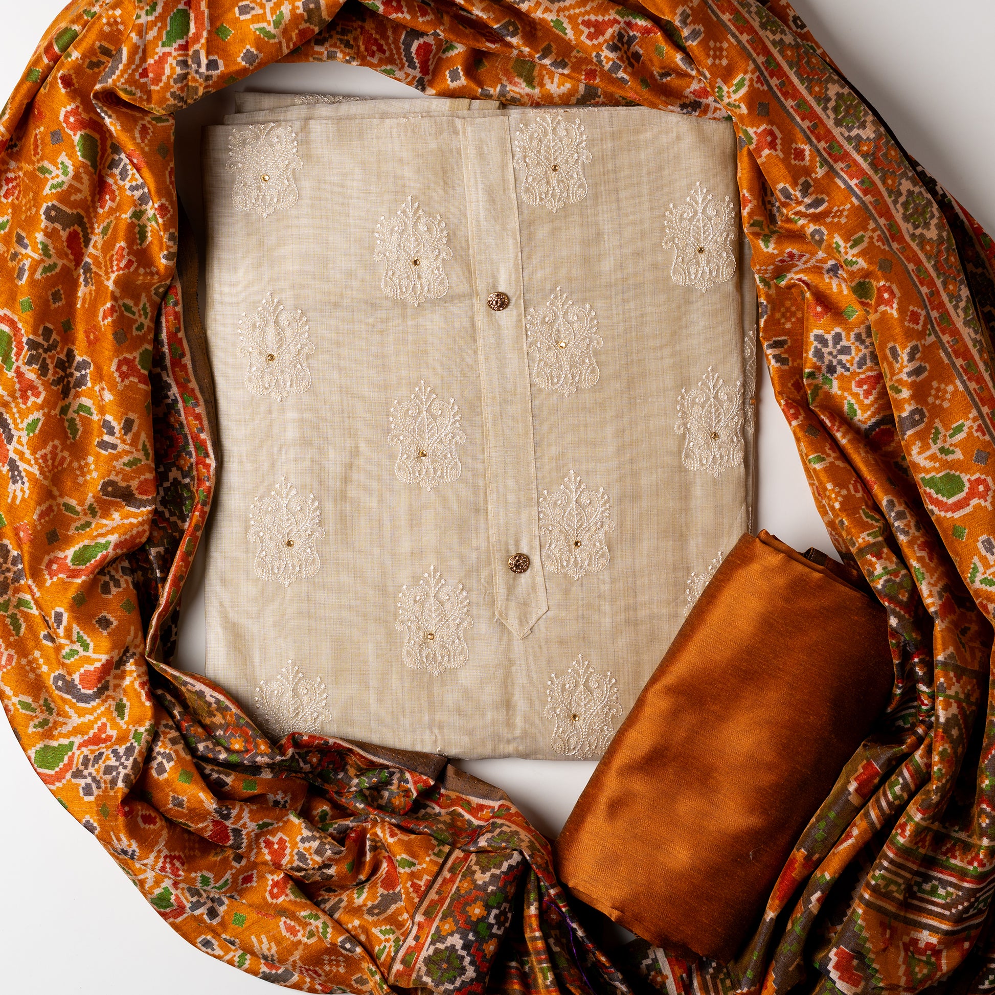 Chanderi silk dress material with embroidery and sequins work, the embroidery work is done with the same color thread of the top which gives a very elegant look. The top has show buttons and golden color piping in the border colorful digital printed silk dupatta , golden brown color cotton silk bottom.