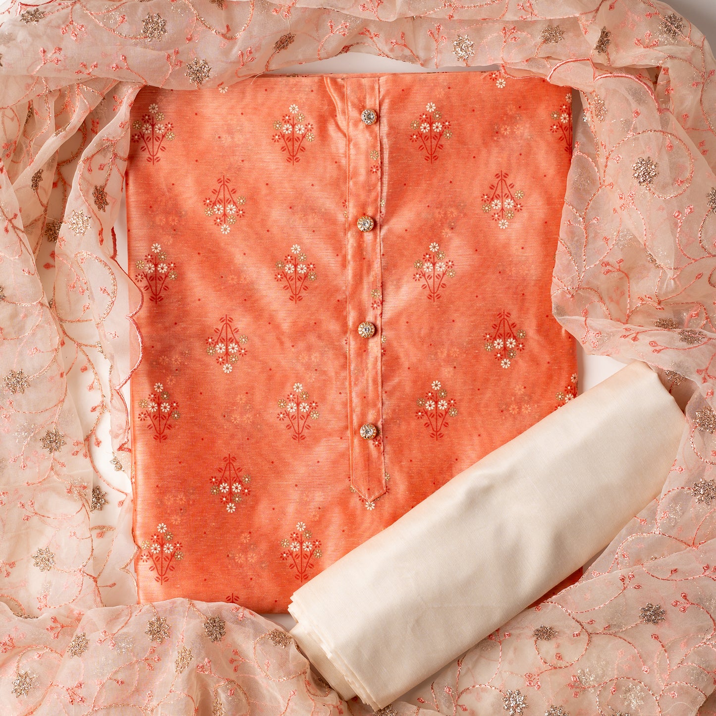 Chanderi silk dress material, peach color top with print design, multi color prints along with gold color . it has show buttons on the neck area. Silk dupatta with very beautiful embroidery work in peach color and golden zari work. Cotton silk plain cream color bottom