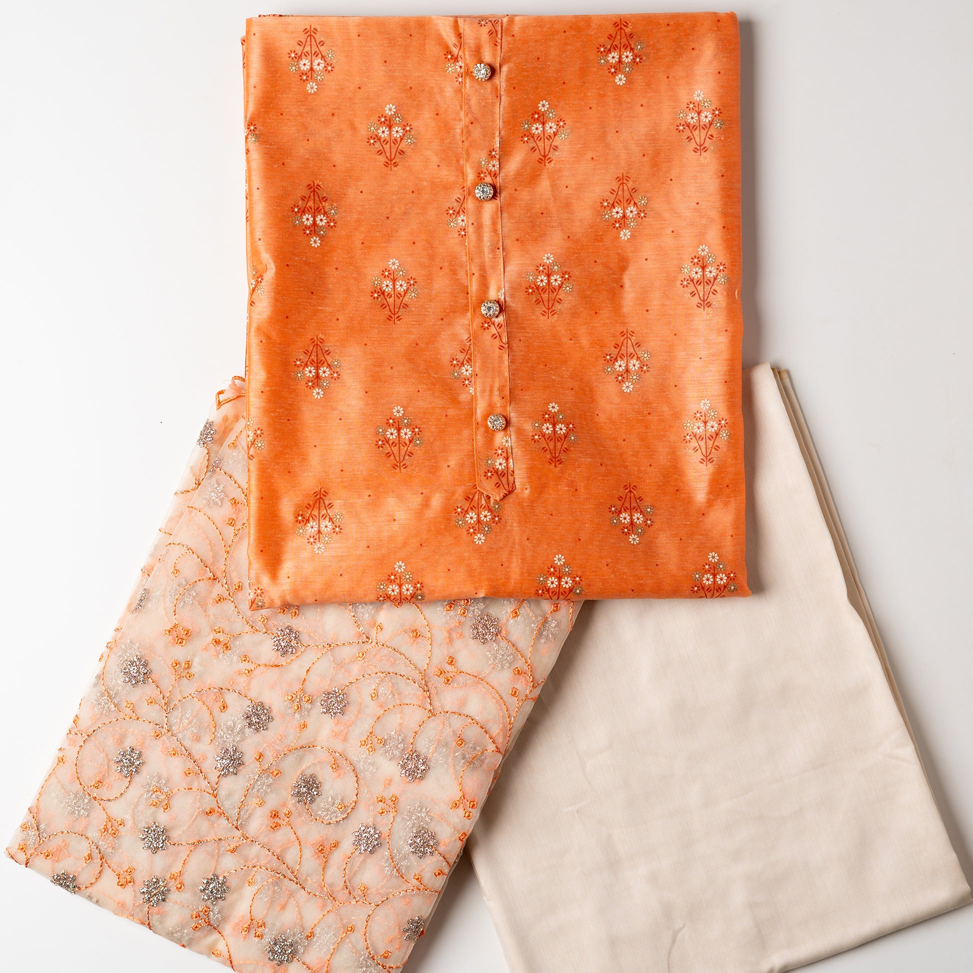 Chanderi silk dress material, coral color top with print design, multi color prints along with gold color . it has show buttons on the neck area. Silk dupatta with very beautiful embroidery work in coral color and golden zari work. Cotton silk plain cream color bottom