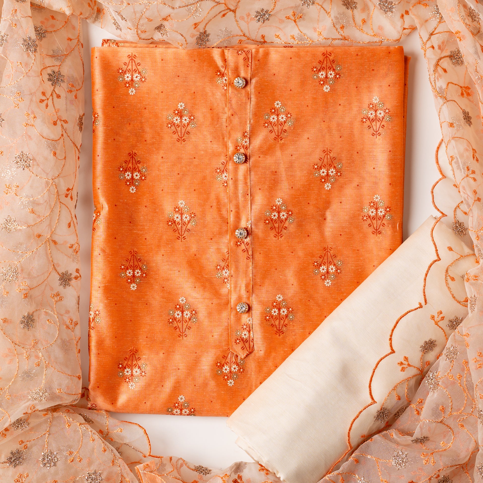 Chanderi silk dress material, coral color top with print design, multi color prints along with gold color . it has show buttons on the neck area. Silk dupatta with very beautiful embroidery work in coral color and golden zari work. Cotton silk plain cream color bottom