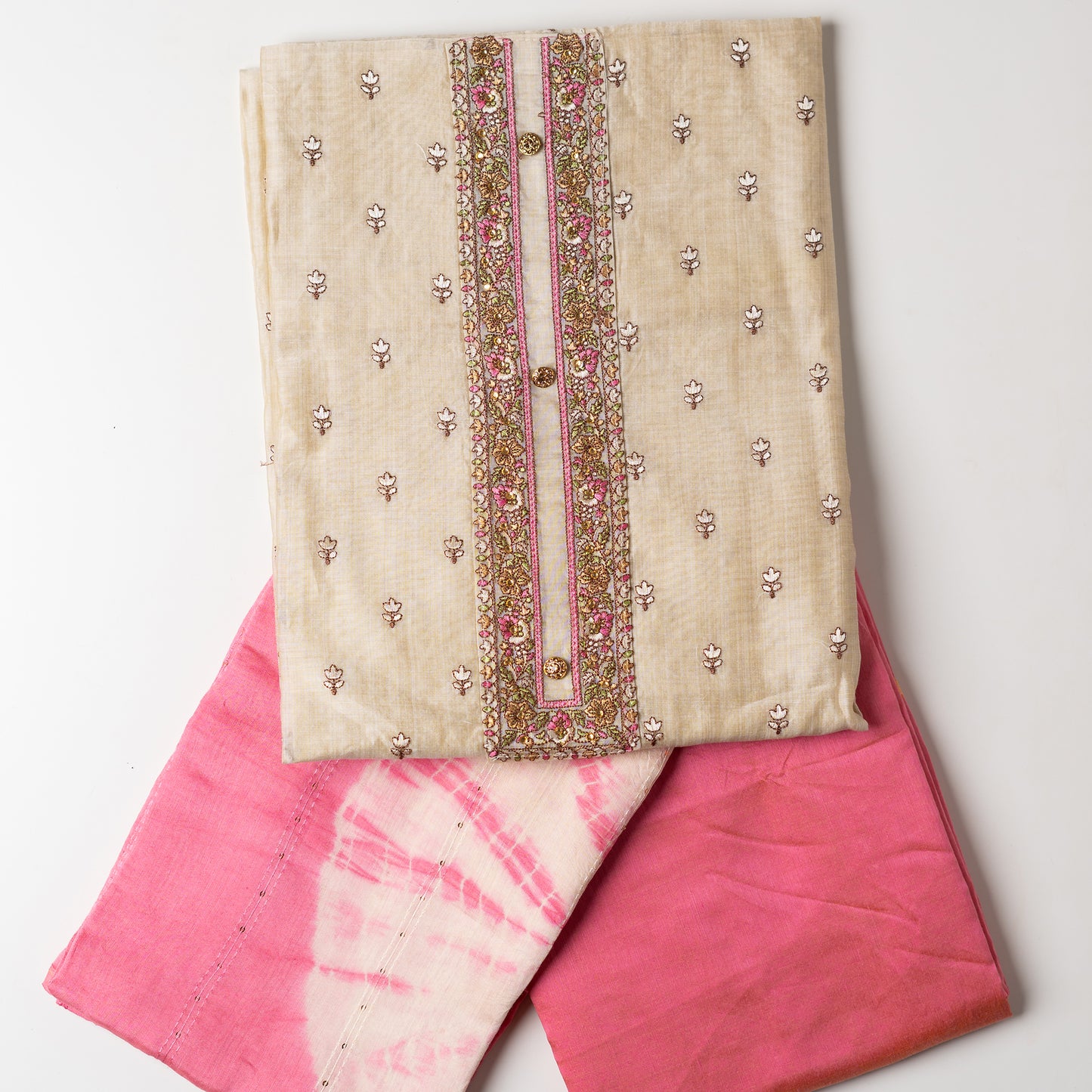 unstitched chanderi silk dress material set, Ivory color Chanderi Silk top with self color floral embroidery all over the body in the front and elegant pink color embroidery work in neck line with show buttons. cotton pink color plain bottom. Pink and cream color silk dupatta with sequins and thread work 
