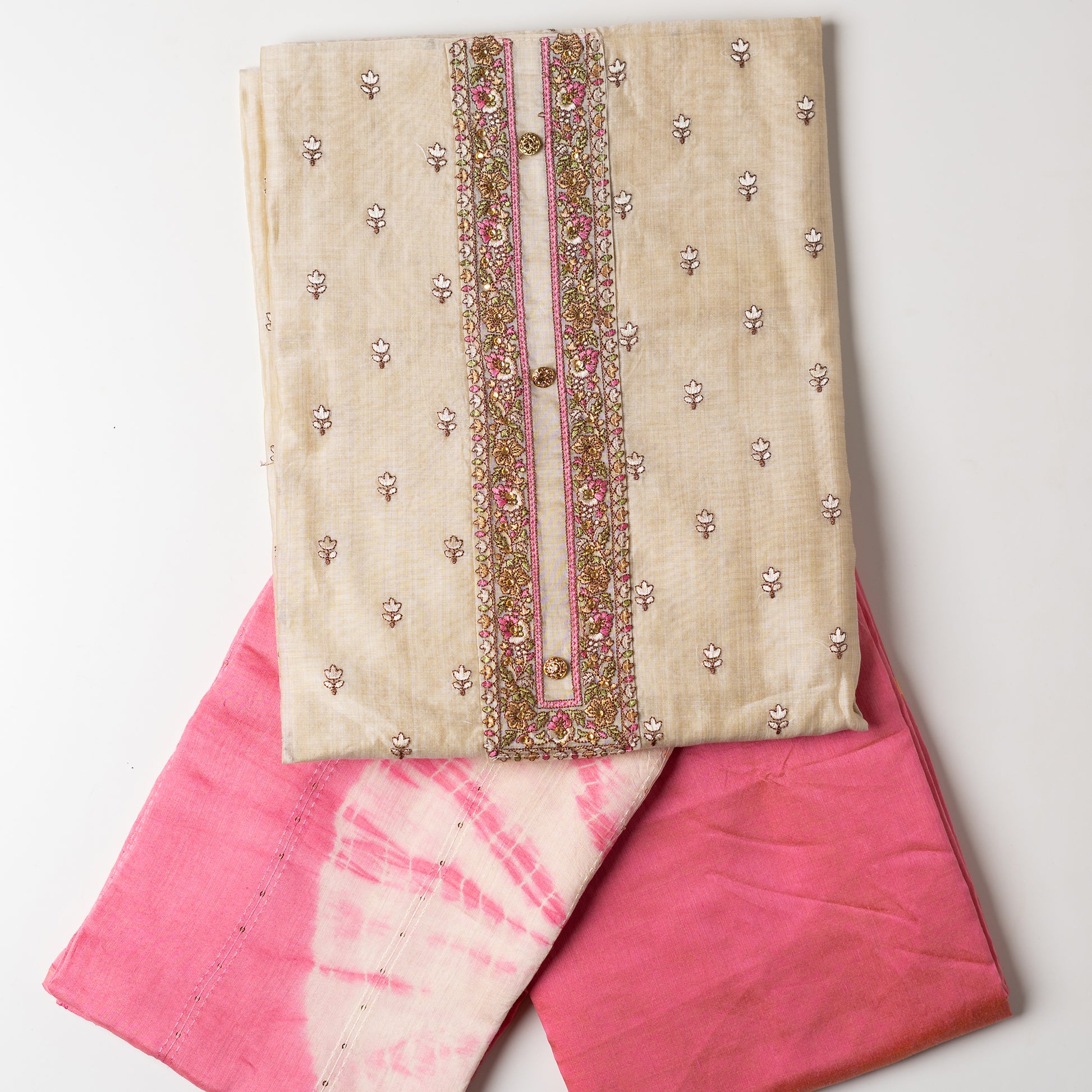 unstitched chanderi silk dress material set, Ivory color Chanderi Silk top with self color floral embroidery all over the body in the front and elegant pink color embroidery work in neck line with show buttons. cotton pink color plain bottom. Pink and cream color silk dupatta with sequins and thread work
