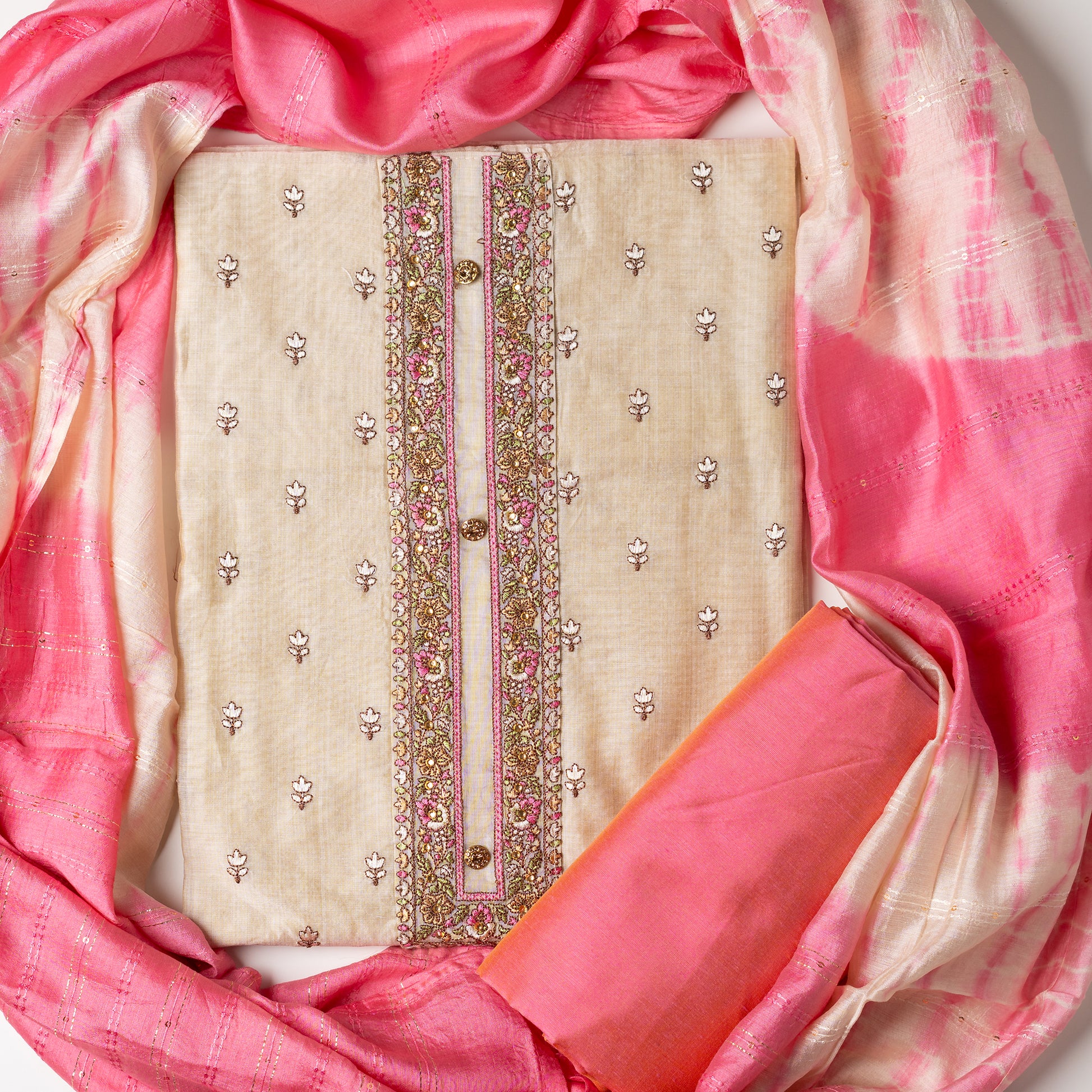 unstitched chanderi silk dress material set, Ivory color Chanderi Silk top with self color floral embroidery all over the body in the front and elegant pink color embroidery work in neck line with show buttons. cotton pink color plain bottom. Pink and cream color silk dupatta with sequins and thread work