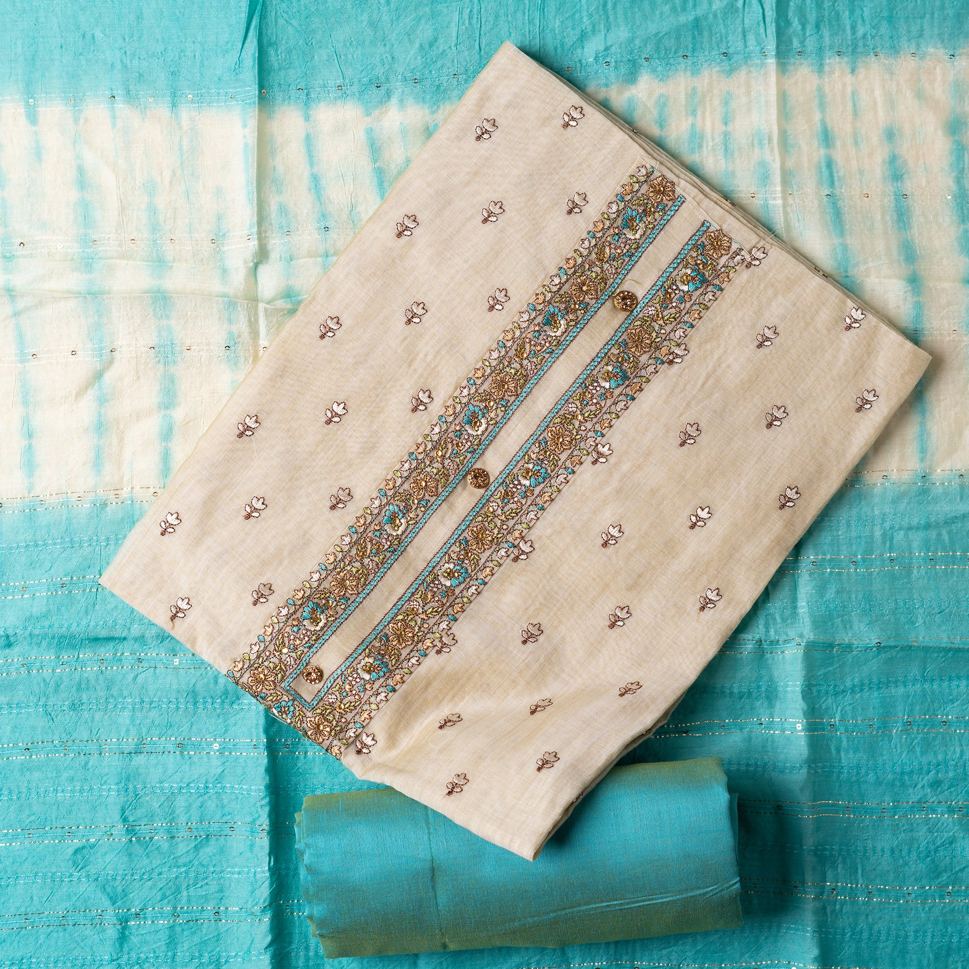 churidhar material set, Ivory color Chanderi Silk top with floral embroidery all over the body in the front and elegant sea green color embroidery work in neck line with show buttons. cotton sea green color plain bottom. Sea green and cream color silk dupatta with sequins and thread work