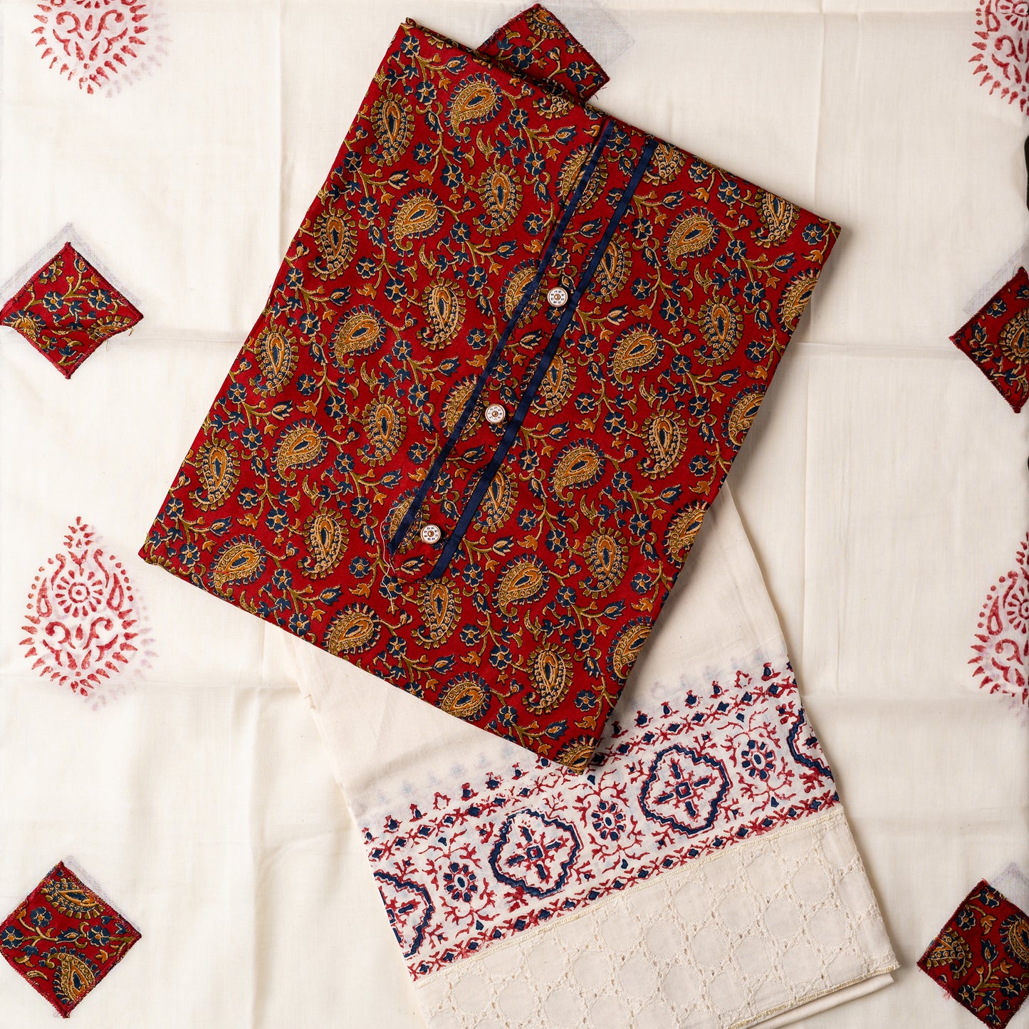 Churidar set, Cotton top with maroon color base and multi color print design, buttons and contrast color piping in yoke, cream color cotton bottom with hakoba design at the edges and print. Cotton dupatta with matching color prints and cut work