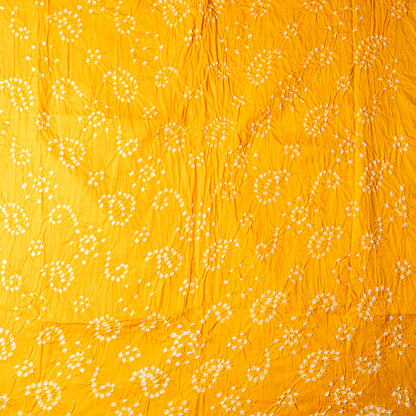 yellow color bandhani top with white bandhej designs.