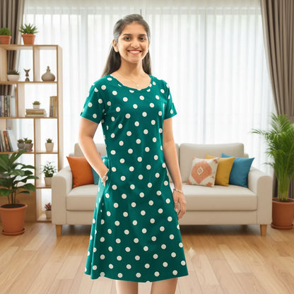 Women wearing hosiery cotton knee length short nighty in green color with polka dot design all over, it has one pocket in right side 
