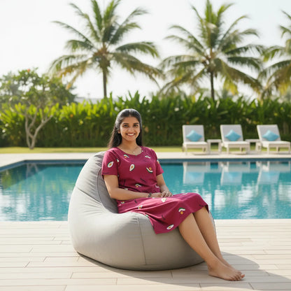 women sitting in front of a swimming pool wearing cotton knee length red color cotton short nighty with all over print