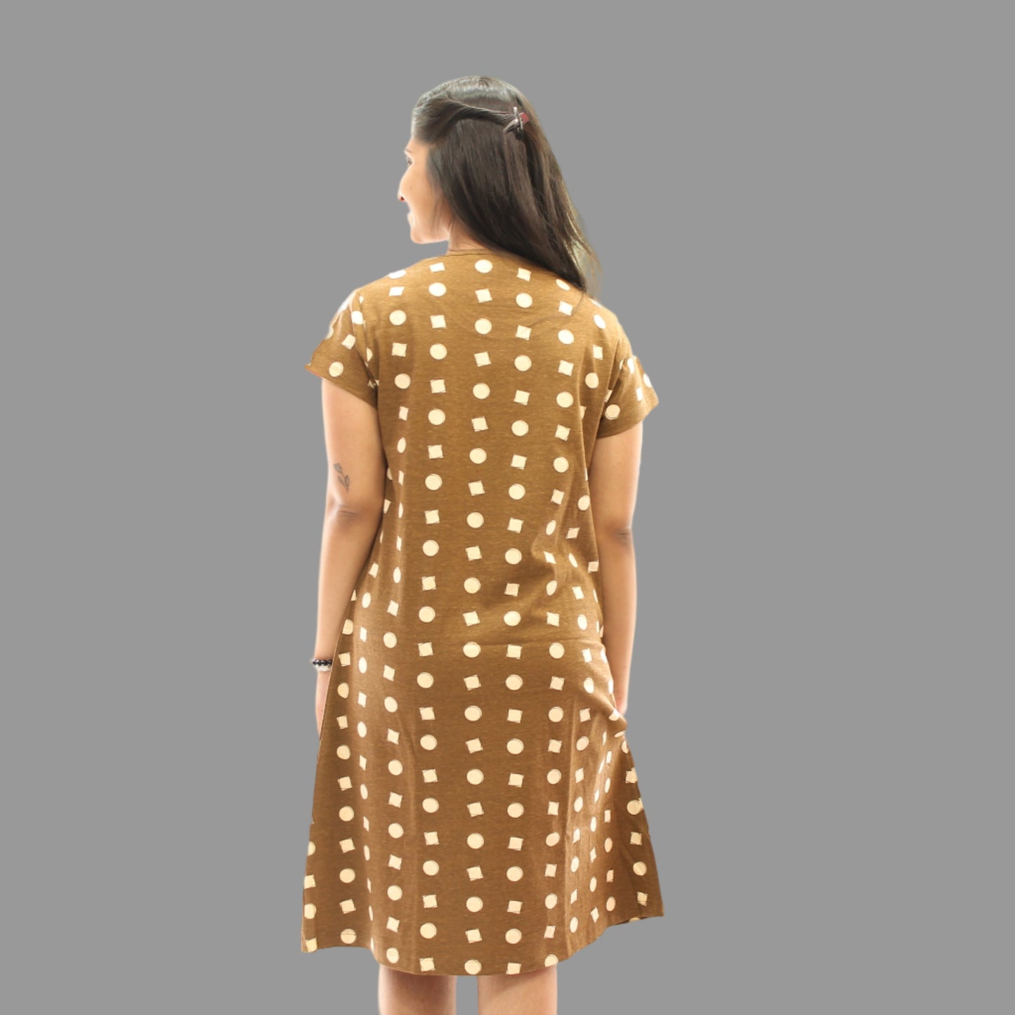 women wearing brown color all over geometric print designs, standing backwards showing the backside view, hands in pocket