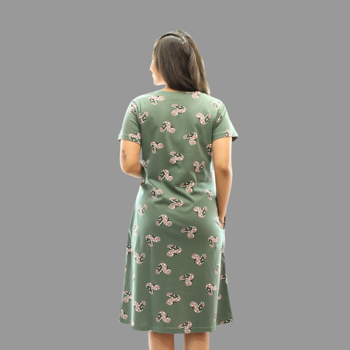 women wearing a light green color short nighty with all over print, standing backwards 
