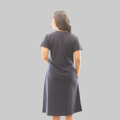 Woman wearing a dark navy dress standing showing the backside view 