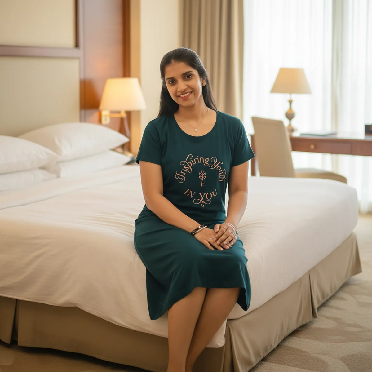 women sitting on a hotel bed wearing bottle green color knee length cotton short nighty