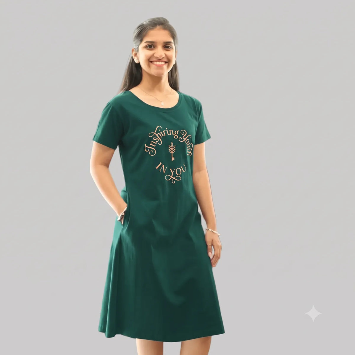 women wearing knee length cotton short nighty in bottle green color , text printed in chest area in round shape, inspiring youth in you