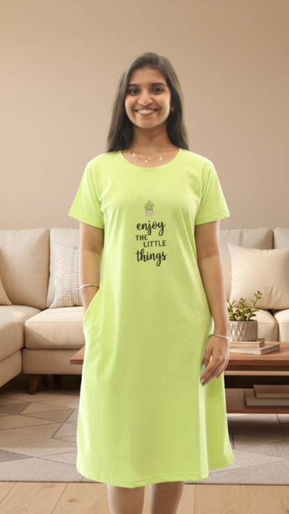 Woman wearing a bright green nightshirt with text in a living room.